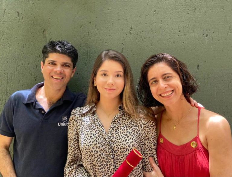 Pai assina diploma de graduação em Direito da filha