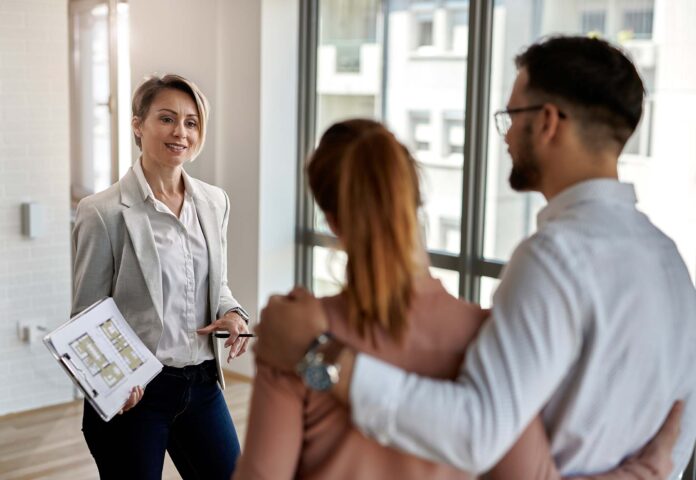 Real estate agent talking to a couple interested in buying new h